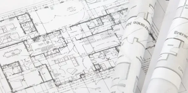 Architectural blueprint featuring detailed floor plan and rolled-up construction drawings.